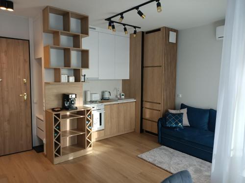 a small kitchen with a blue couch in a room at Apartament Maris Gdynia - Śródmieście - Klimatyzacja - Prywatny Parking in Gdynia