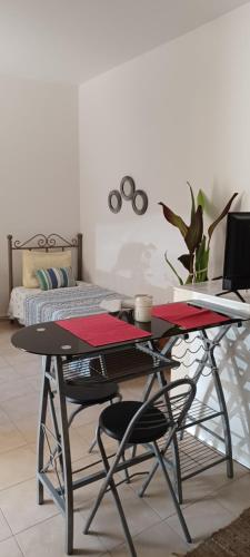 a table with two chairs and a laptop on a bed at Quiet studio near to the airport 1 in Heraklio