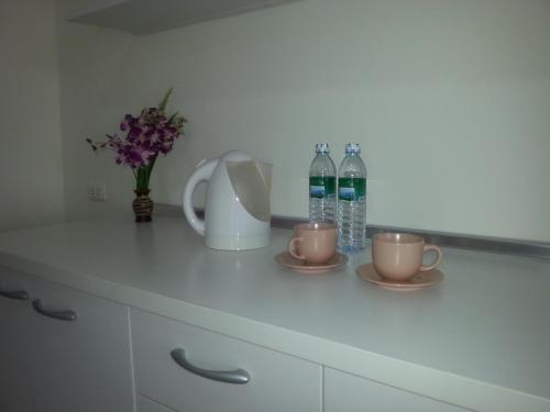 a kitchen counter with two cups and two bottles of water at The Green House in Kata Beach