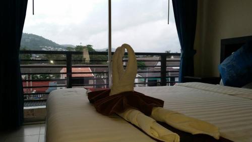 a bedroom with a bed with a view of a balcony at The Green House in Kata Beach