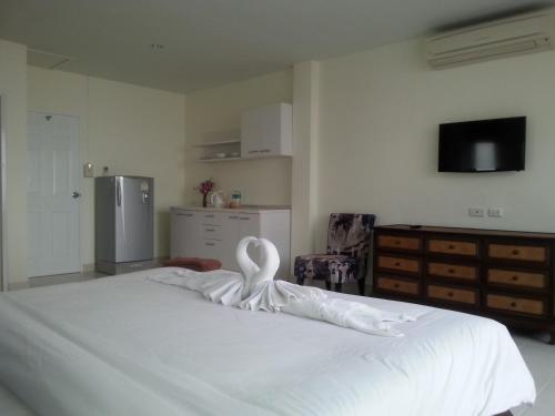 a bedroom with a white bed with a swan on it at The Green House in Kata Beach