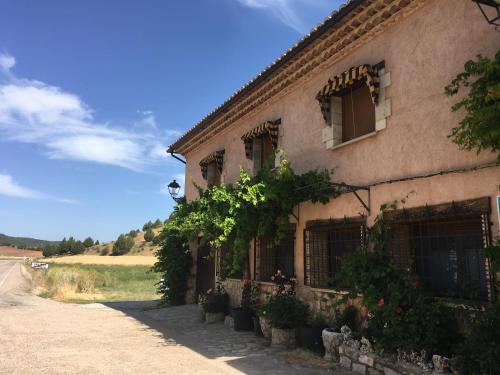 Casa Rural Salinas de Armalla في Arias: مبنى يوجد به نباتات على جانب الطريق