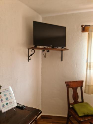 a living room with a tv on a wall at Finca Los Angeles Hospederia & Sociales in Huasca de Ocampo