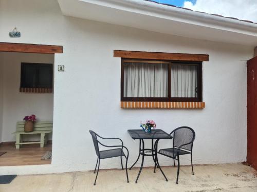 a table and chairs in front of a house at Finca Los Angeles Hospederia & Sociales in Huasca de Ocampo