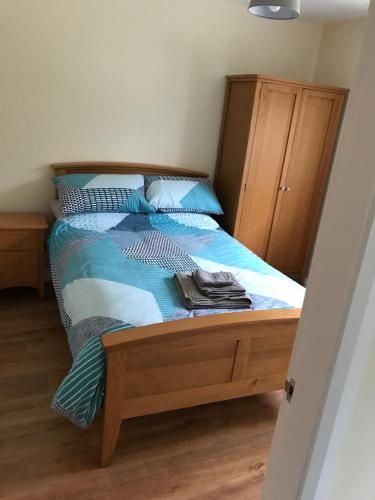 a bedroom with a bed with a blue comforter at Mourne country cottage in Warrenpoint