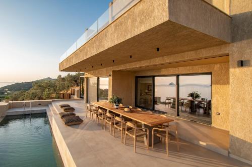 a house with a pool and a table and chairs at Villa myporos in Poros