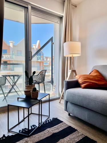 - un salon avec un canapé et une grande fenêtre dans l'établissement Cosy Appartement vue mer, à Camiers