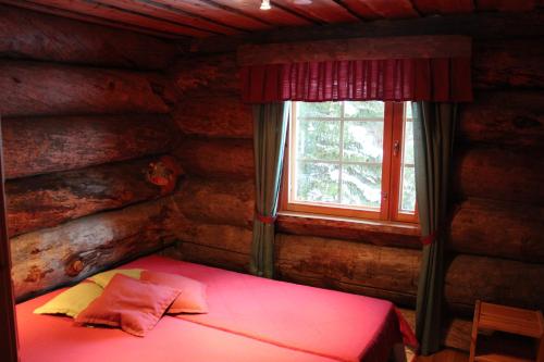 a small bedroom with a bed in a log cabin at Rukanhelmi Cottage in Ruka