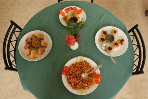 un tavolo verde con piatti di cibo sopra di Ayur County Resort a Chinnakanal