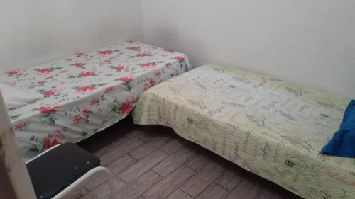 1 dormitorio pequeño con 2 camas y 1 silla en Pousada Vera, en São Paulo