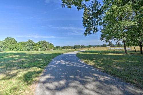 a dirt road in a field with a tree at Country Cabin with Wraparound Deck and Views! in Springdale