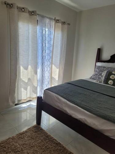 a bedroom with a bed and a window with curtains at Tranquil 2 bedroom townhouse in Discovery Bay in Discovery Bay
