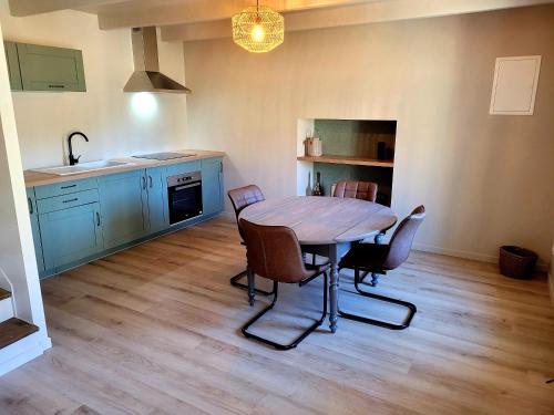 uma cozinha e sala de jantar com mesa e cadeiras em Ti Fanch, maison proche de Quimper em Landudal