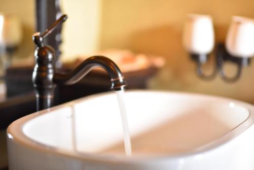a bathroom sink with water running from a faucet at The Capoe House in Haputale