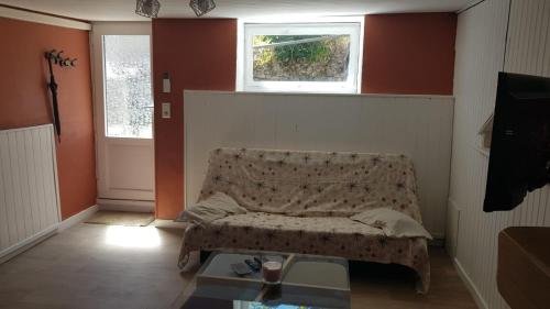 - un salon avec un canapé et une fenêtre dans l'établissement Maisonnette 6 personnes en Auvergne à Saint Remy sur Durolle, 