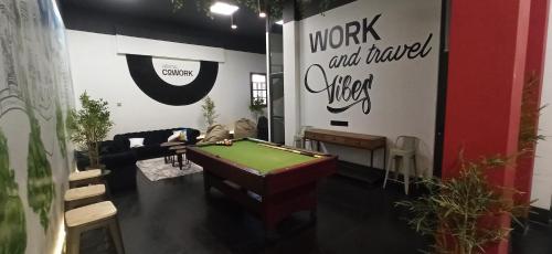 a room with a pool table and a sign with work and wanted music at Hostel Boutique Merced 88 in Santiago