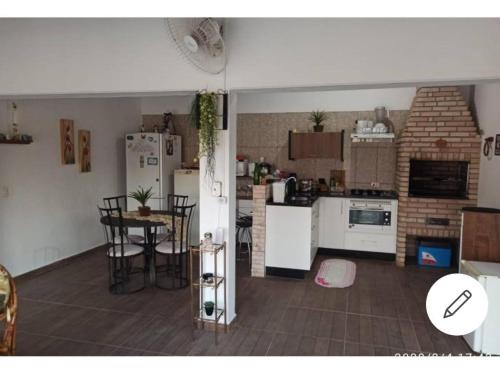 a kitchen with white appliances and a table and chairs at Chácara Mig&Vá in Itupeva