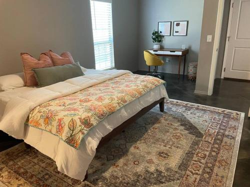 a bedroom with a bed with a rug and a desk at 10 mins KING Smart TV Garage W/D in Amarillo