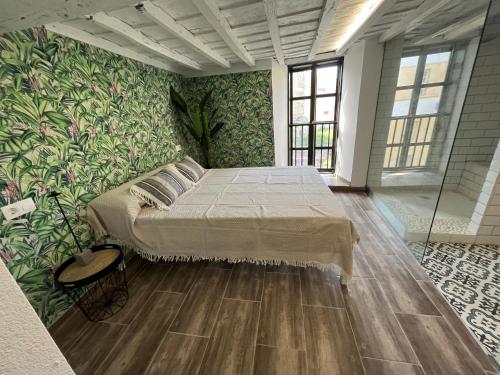 ルーゴにあるHOSTEL PORTONのベッドと緑の壁のある寝室