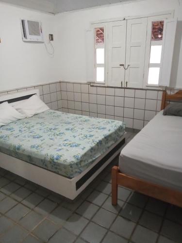 um quarto com 2 camas e 2 janelas em Pé de mato chalé em Estância