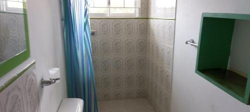 bagno con tenda per la doccia e servizi igienici di Finca El Jardin SOLO PARA FAMILIAS a Tocaima