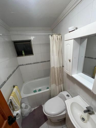 y baño con aseo, lavabo y bañera. en alojamiento diario con baño compartido, en Calama