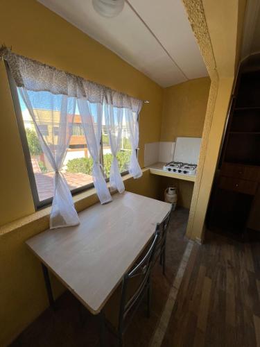 cocina con mesa y ventana grande en alojamiento diario con baño compartido, en Calama