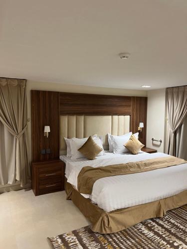 una grande camera da letto con un grande letto con lenzuola bianche di الاتحاد الذهبية للشقق المخدومة 2 a Al Ahsa