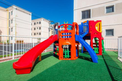 a playground with a slide on the grass at Apto Solar do Coqueiro in Campos dos Goytacazes