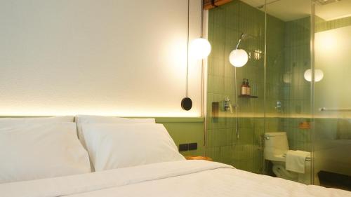 a bedroom with a bed and a shower and a toilet at karaarom hotel in Bangkok