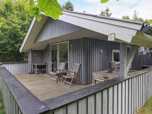 Casa con terraza de madera con sillas y mesa en 5 person holiday home in lb k, en Ålbæk