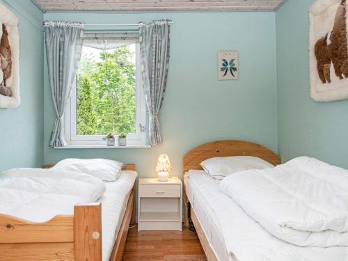 2 camas individuales en una habitación con ventana en Holiday home Ebeltoft CXCIV en Ebeltoft