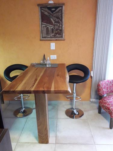 a wooden table with two chairs in a room at Base Manzano in Tunuyán