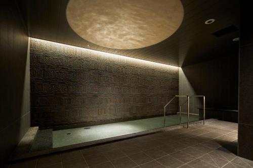a swimming pool in a building with a circle on the wall at HOTEL AMANEK Kanazawa in Kanazawa
