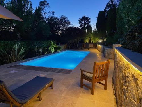 - une piscine avec un banc et une chaise à côté dans l'établissement Apartment in Pégomas with Private Pool, à Pégomas