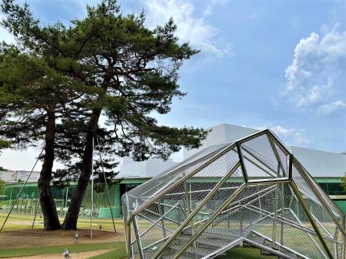 a metal structure next to a tree next to a building at HOTEL AMANEK Kanazawa in Kanazawa