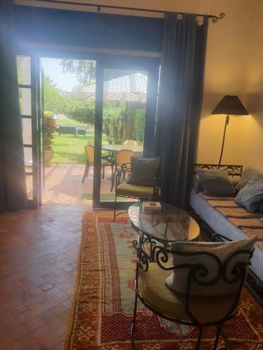 a living room with a couch and a table and a patio at Villa à Bouznika Bay-plage et golf in Bouznika
