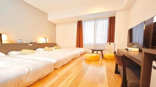Habitación de hotel con 2 camas, escritorio y TV. en Tokyo Bay Ariake Washington Hotel en Tokio