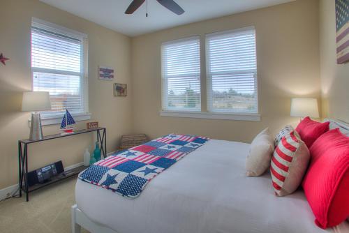 a bedroom with a large bed with red and blue pillows at Sea Stars Stripes Beach Cottage in Ocean Shores