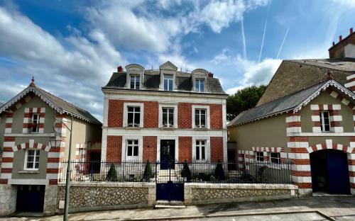 een groot bakstenen huis met een poort voor twee gebouwen bij Maison Loire in Blois