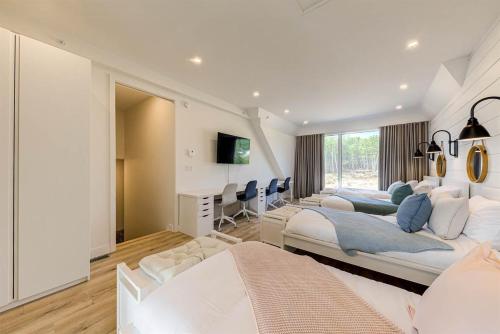 a bedroom with three beds and a desk at Les Immeubles Charlevoix 750-409 in Baie-Saint-Paul