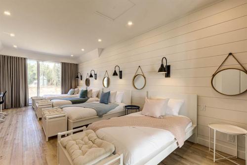 1 dormitorio con 3 camas y espejo en Les Immeubles Charlevoix 750-409 en Baie-Saint-Paul
