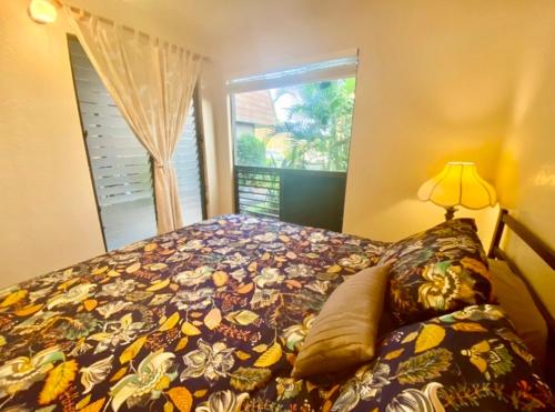 1 dormitorio con 1 cama grande y ventana en Black Sands Beach Condo with Full Kitchen en Pahala