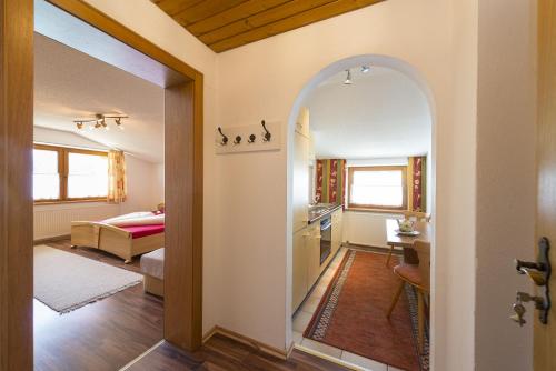 einen Torbogen in ein Wohnzimmer mit einer Küche in der Unterkunft Ferienhof Auerhof in Walchsee