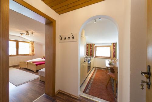 an arched doorway into a living room with a kitchen at Ferienhof Auerhof in Walchsee