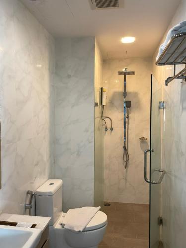 a bathroom with a shower and a toilet and a sink at Locals Prio ChiangMai Central Airport Plaza in Chiang Mai