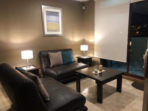 a living room with a couch and a chair and a table at Hermoso penthouse en el centro histórico in Zacatecas