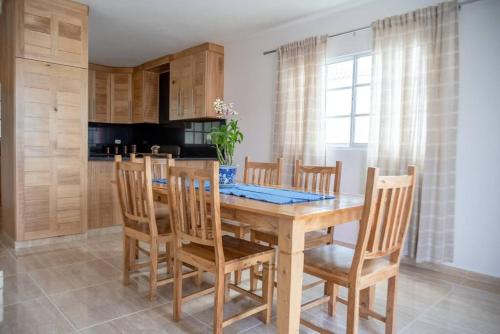 comedor con mesa de madera y sillas en Casa Familiar en el Valle de Constanza, en Constanza