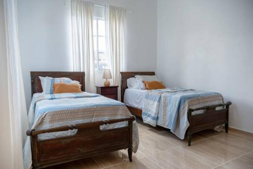 1 dormitorio con 2 camas y ventana en Casa Familiar en el Valle de Constanza, en Constanza