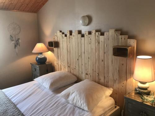 une chambre avec un lit avec une tête de lit en bois dans l'établissement Petit Duplex Centre-Ville, Près Plage, Terrasse, Parking, Animaux Acceptés - FR-1-22-244, à La Tranche-sur-Mer